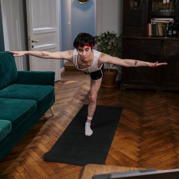 Man holding a difficult yoga balance pose showing strength.